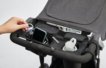 Roam Parent Organizer opened with water bottle, phone, keys, and a pacifier